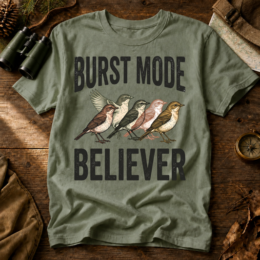 Burst Mode Believer Bird Photography Tee in Bay, centered front design on a birdwatching flat-lay mockup