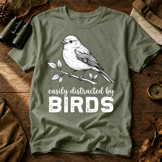 Easily Distracted by Birds Sketch Tee in Bay, centered front design on a birdwatching flat-lay mockup
