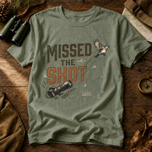 Missed the Shot Bird Photography Tee in Bay, centered front design on a birdwatching flat-lay mockup