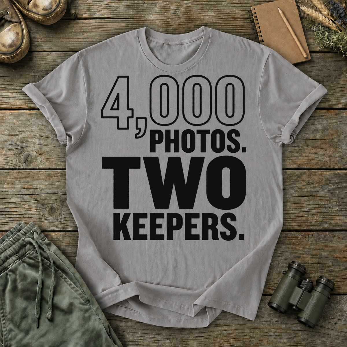 4,000 Photos Two Keepers Bird Photography Tee in Grey, centered front design on a birdwatching flat-lay mockup