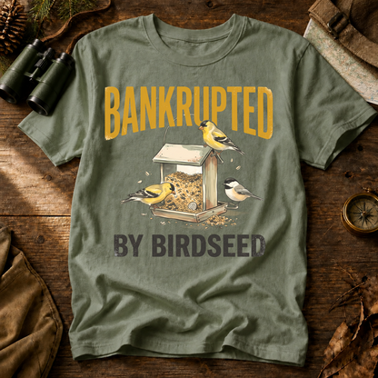 Bankrupted by Birdseed Backyard Birds Tee in Bay, centered front design on a birdwatching flat-lay mockup