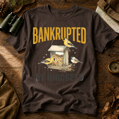 Bankrupted by Birdseed Backyard Birds Tee in Espresso, centered front design on a birdwatching flat-lay mockup