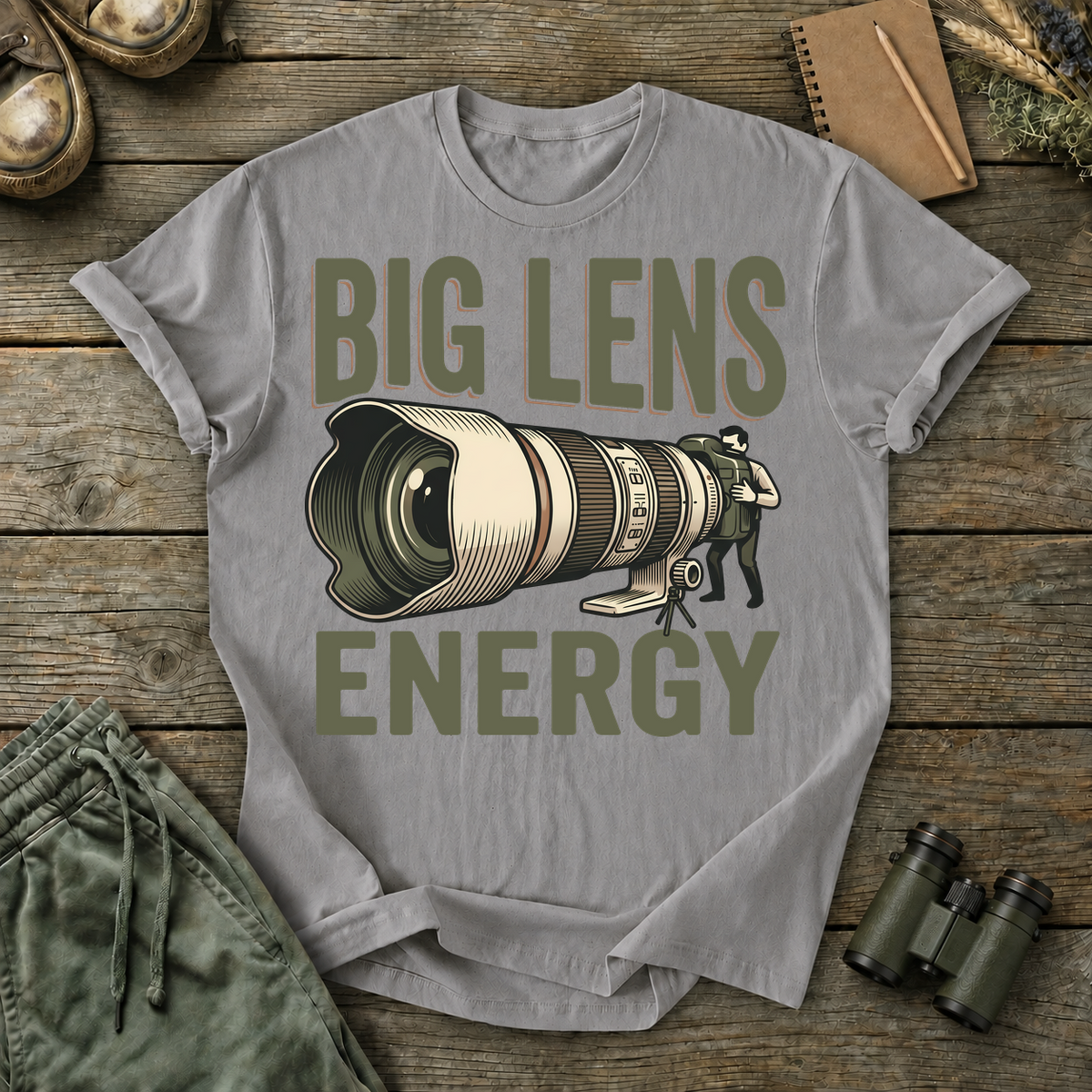 Big Lens Energy Bird Photography Tee in Grey, centered front design on a birdwatching flat-lay mockup