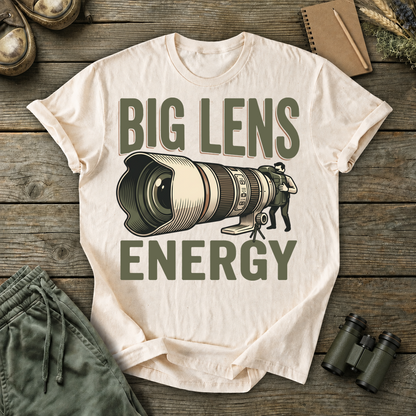 Big Lens Energy Bird Photography Tee in Ivory, centered front design on a birdwatching flat-lay mockup