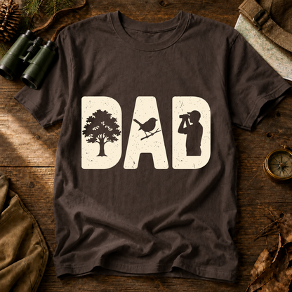 Bird Dad Silhouette Tee in Espresso, centered front design on a birdwatching flat-lay mockup