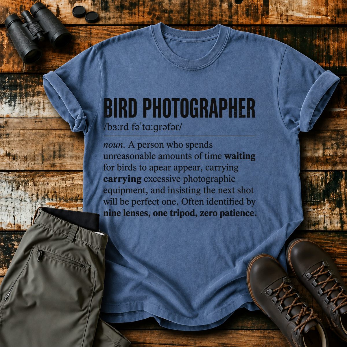 Bird Photographer Definition Tee in Blue Jean, centered front design on a birdwatching flat-lay mockup