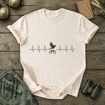 Birding Heartbeat Tee in Ivory, centered front design on a birdwatching flat-lay mockup