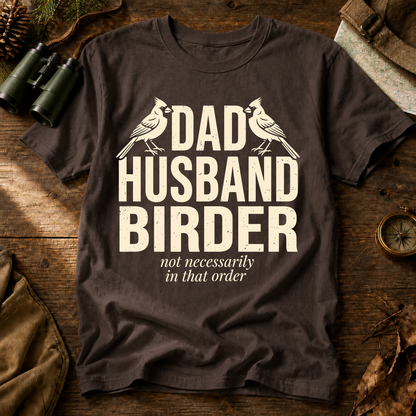 Dad Husband Birder Tee in Espresso, centered front design on a birdwatching flat-lay mockup