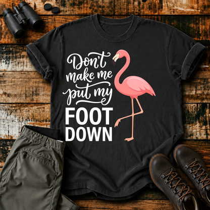 Flamingo Foot Down Tee in Black, centered front design on a birdwatching flat-lay mockup