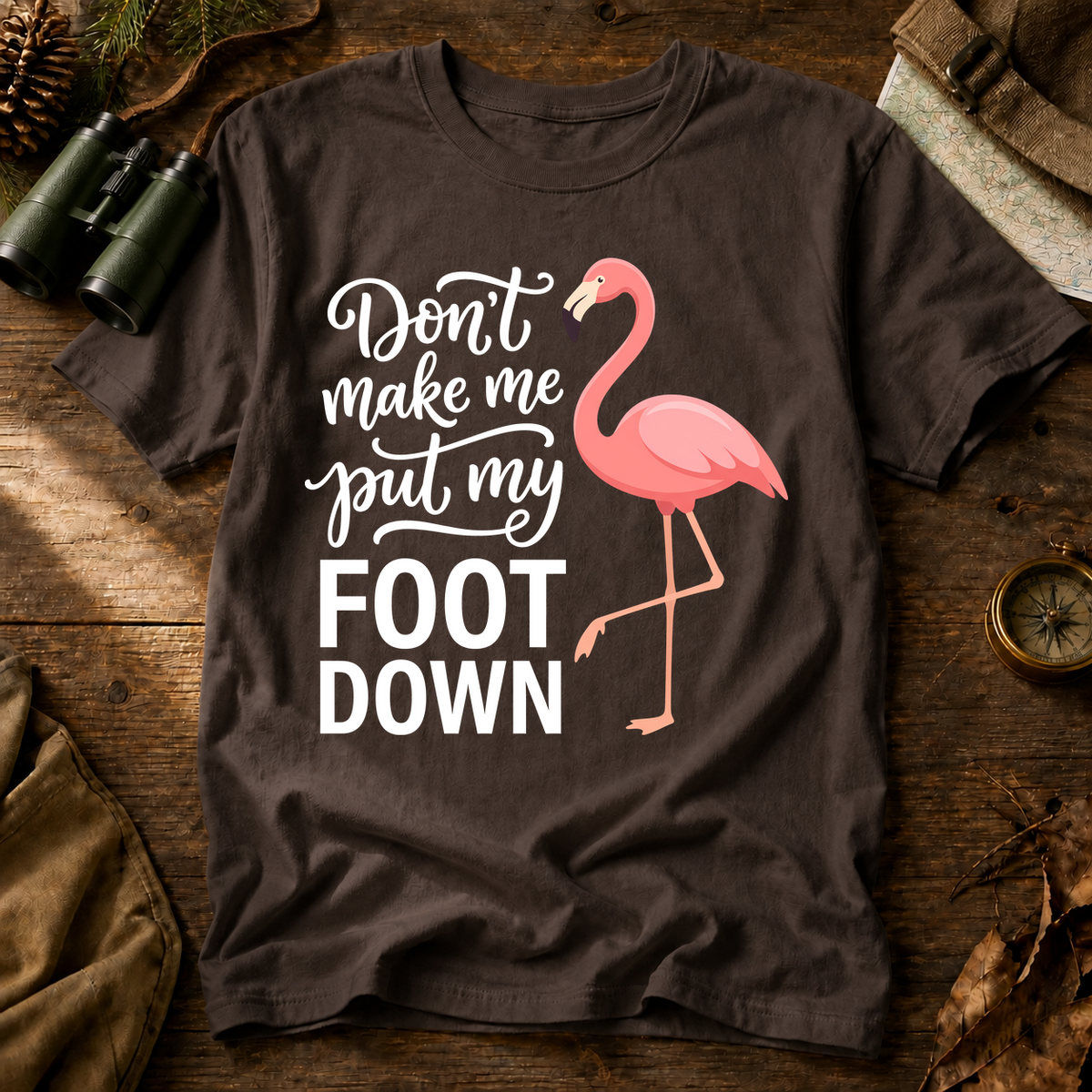 Flamingo Foot Down Tee in Espresso, centered front design on a birdwatching flat-lay mockup