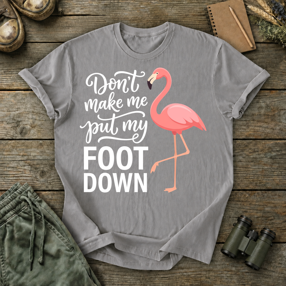 Flamingo Foot Down Tee in Grey, centered front design on a birdwatching flat-lay mockup