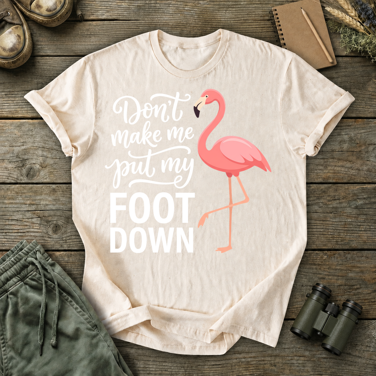 Flamingo Foot Down Tee in Ivory, centered front design on a birdwatching flat-lay mockup