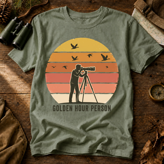 Golden Hour Bird Photographer Tee in Bay, centered front design on a birdwatching flat-lay mockup