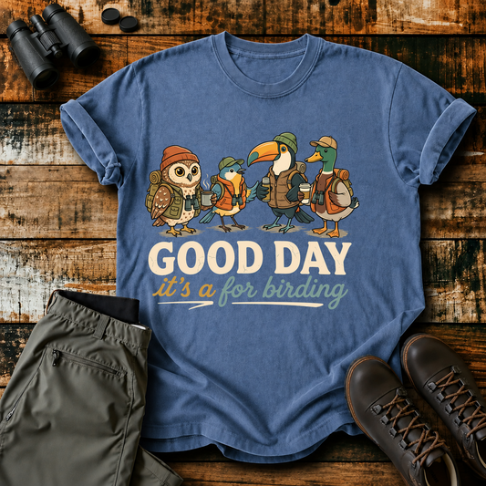 Good Day for Birding Adventure Flock Tee in Blue Jean, centered front design on a birdwatching flat-lay mockup