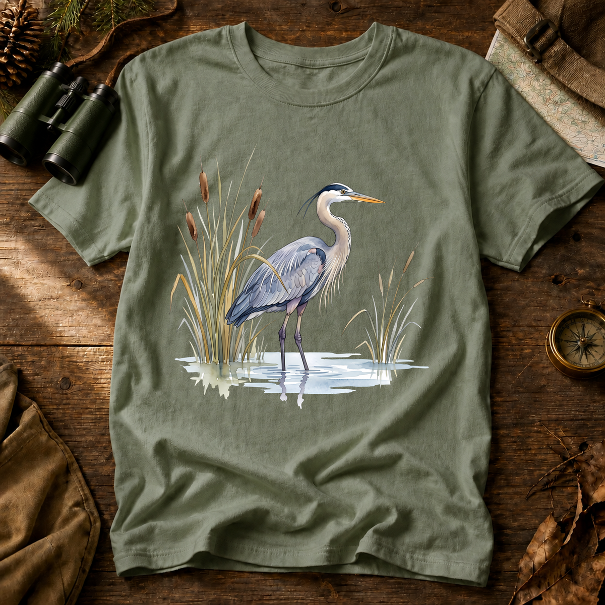 Great Blue Heron Wetland Watercolor Tee in Bay laid beside field gear