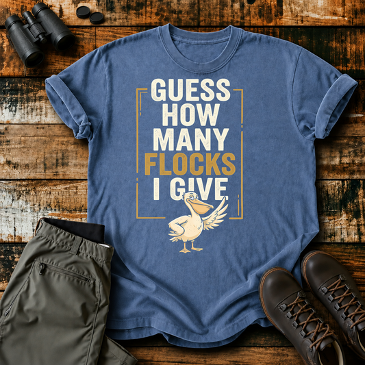 Guess How Many Flocks I Give Tee in Blue Jean, centered front design on a birdwatching flat-lay mockup