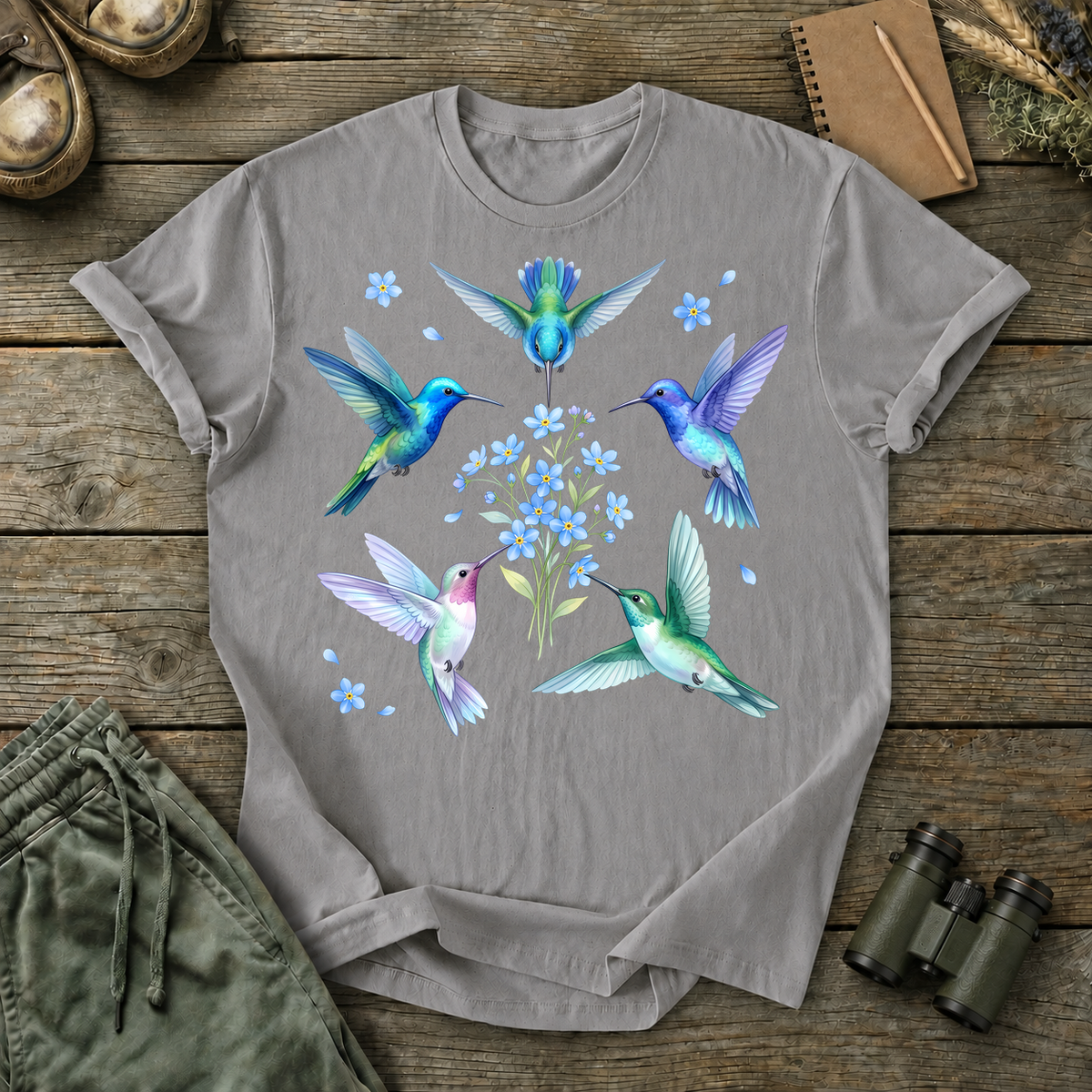 Hummingbird Floral Circle Tee in Grey, centered front design on a birdwatching flat-lay mockup