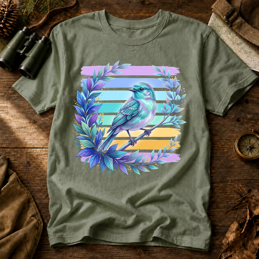 Iridescent Songbird Laurel Tee in Bay, centered front design on a birdwatching flat-lay mockup
