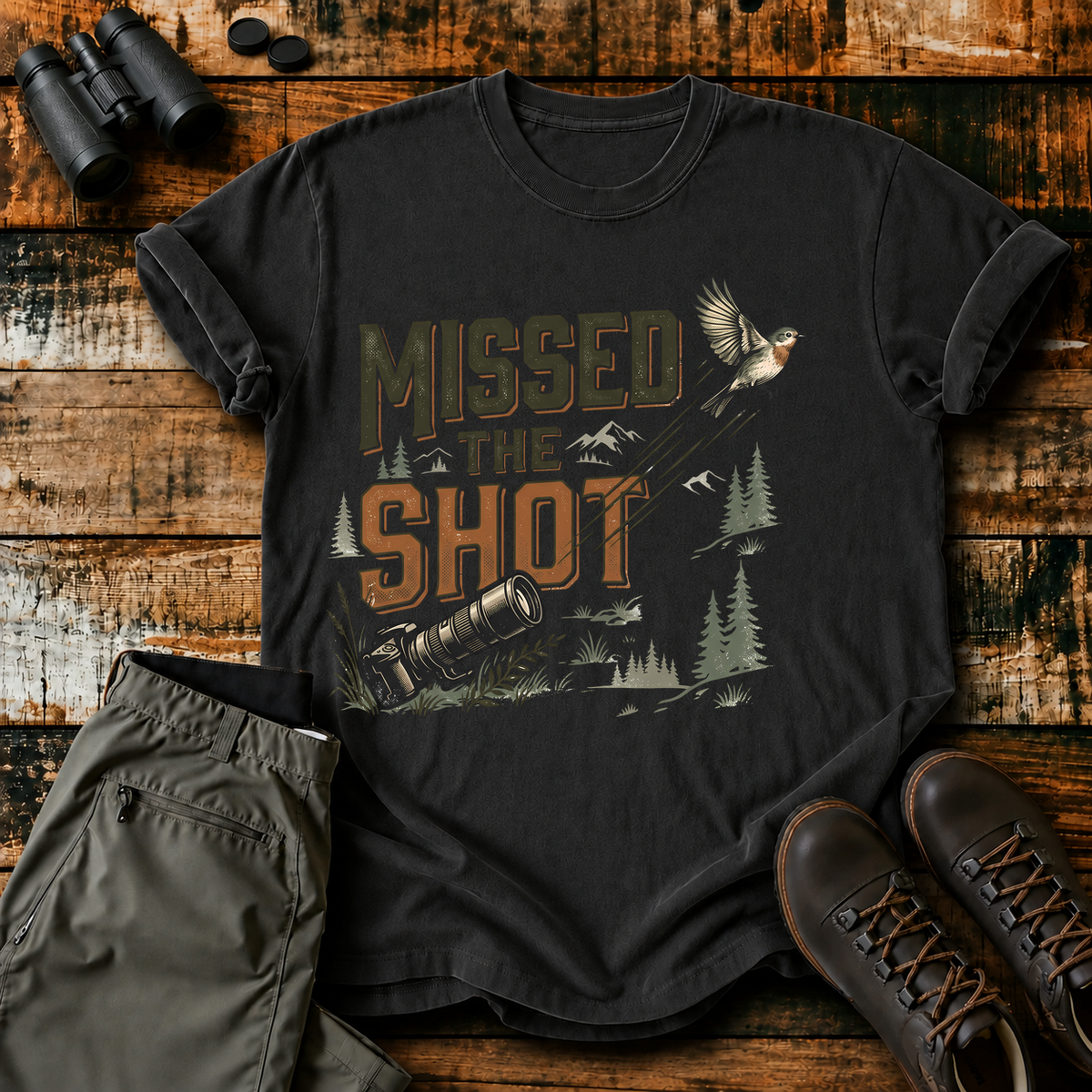 Missed the Shot Bird Photography Tee in Black, centered front design on a birdwatching flat-lay mockup