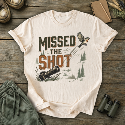 Missed the Shot Bird Photography Tee in Ivory, centered front design on a birdwatching flat-lay mockup