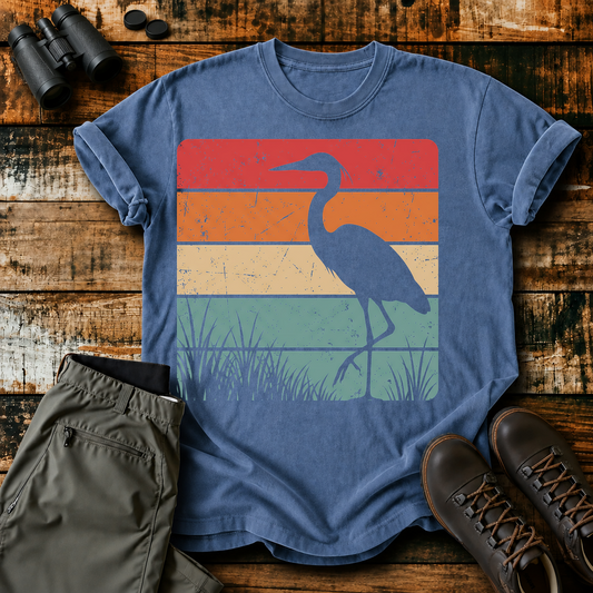 Retro Heron Wetland Tee in Blue Jean, centered front design on a birdwatching flat-lay mockup