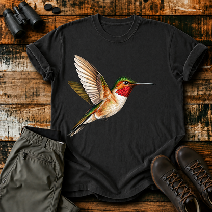 Ruby-Throated Hummingbird Flight Tee in Black, centered front design on a birdwatching flat-lay mockup