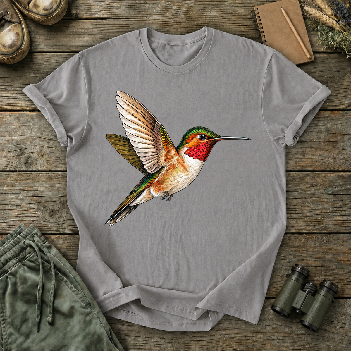 Ruby-Throated Hummingbird Flight Tee in Grey, centered front design on a birdwatching flat-lay mockup
