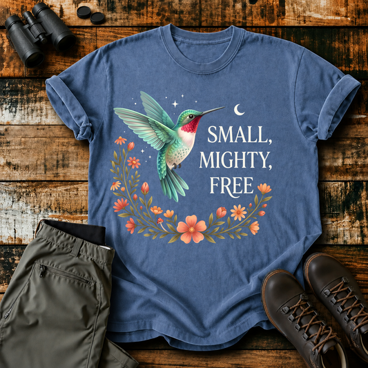 Small Mighty Free Hummingbird Tee in Blue Jean, centered front design on a birdwatching flat-lay mockup