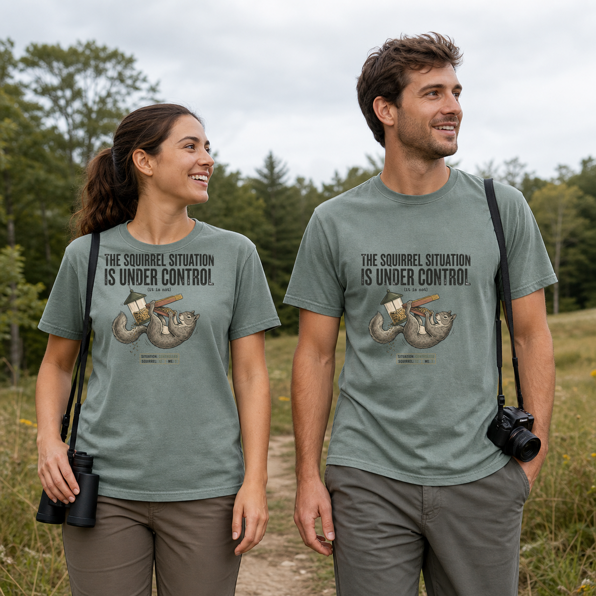 Female and male models wearing the Squirrel Situation Under Control Tee in Bay, with the artwork centered on both shirts
