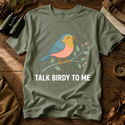 Talk Birdy to Me Songbird Tee in Bay, centered front design on a birdwatching flat-lay mockup