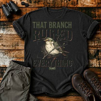 That Branch Ruined Everything Bird Photography Tee in Black, centered front design on a birdwatching flat-lay mockup