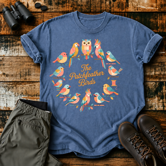 The Patchfeather Birds Quilt Flock Tee in Blue Jean, centered front design on a birdwatching flat-lay mockup