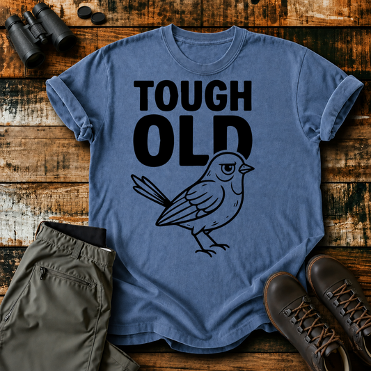 Tough Old Bird Tee in Blue Jean, centered front design on a birdwatching flat-lay mockup
