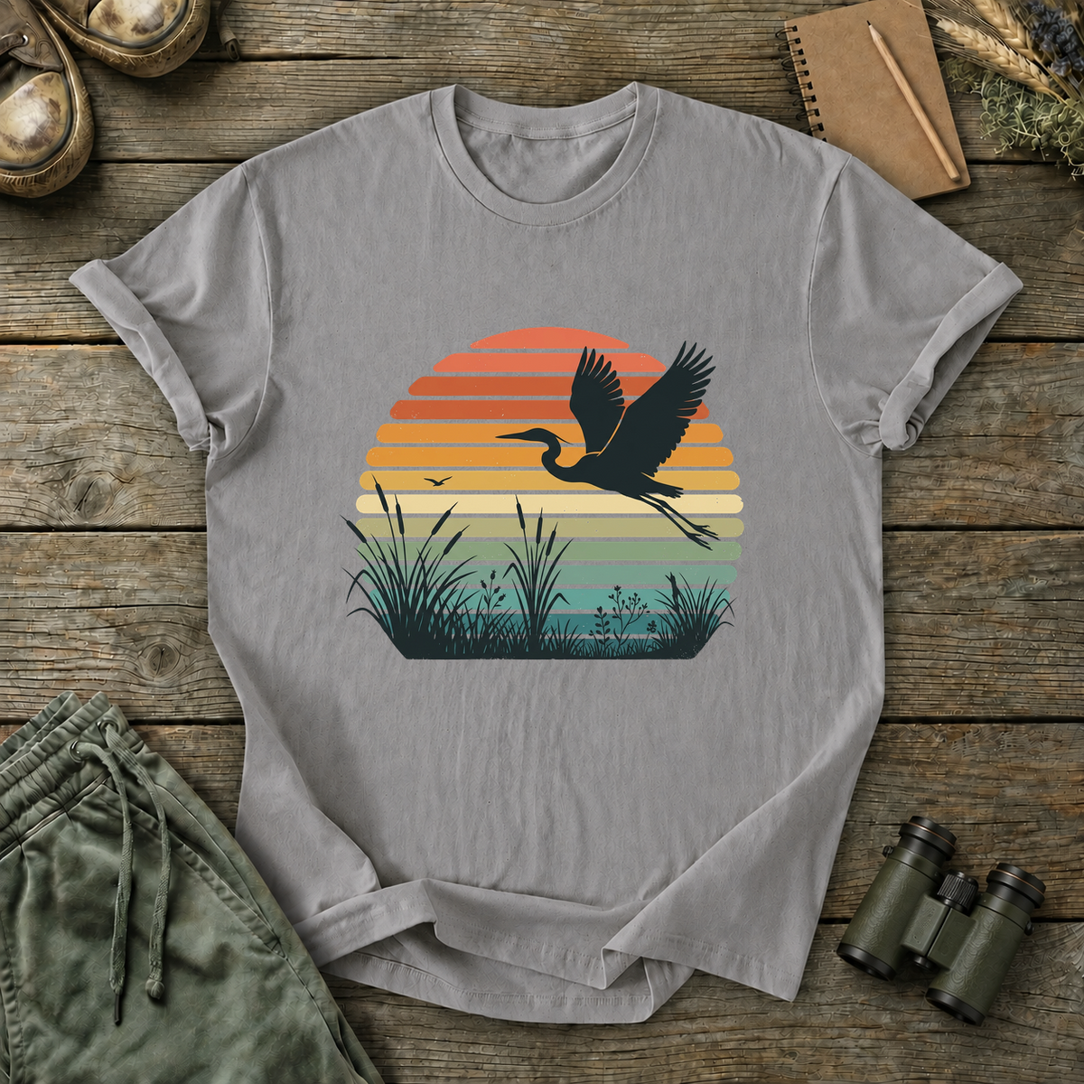 Vintage Sunset Marsh Bird Tee in Grey, centered front design on a birdwatching flat-lay mockup