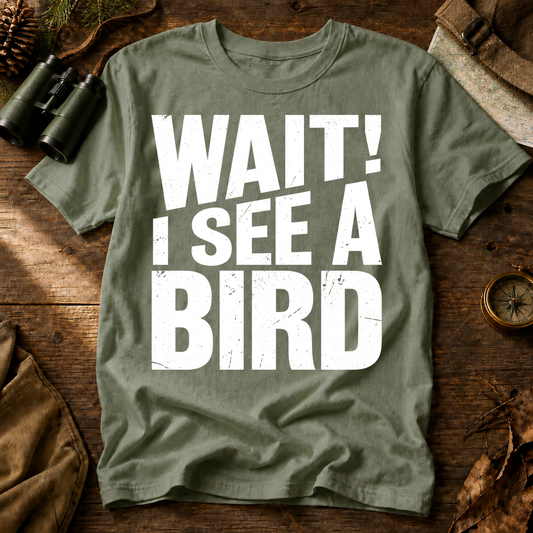 Wait I See a Bird Tee in Bay, centered front design on a birdwatching flat-lay mockup